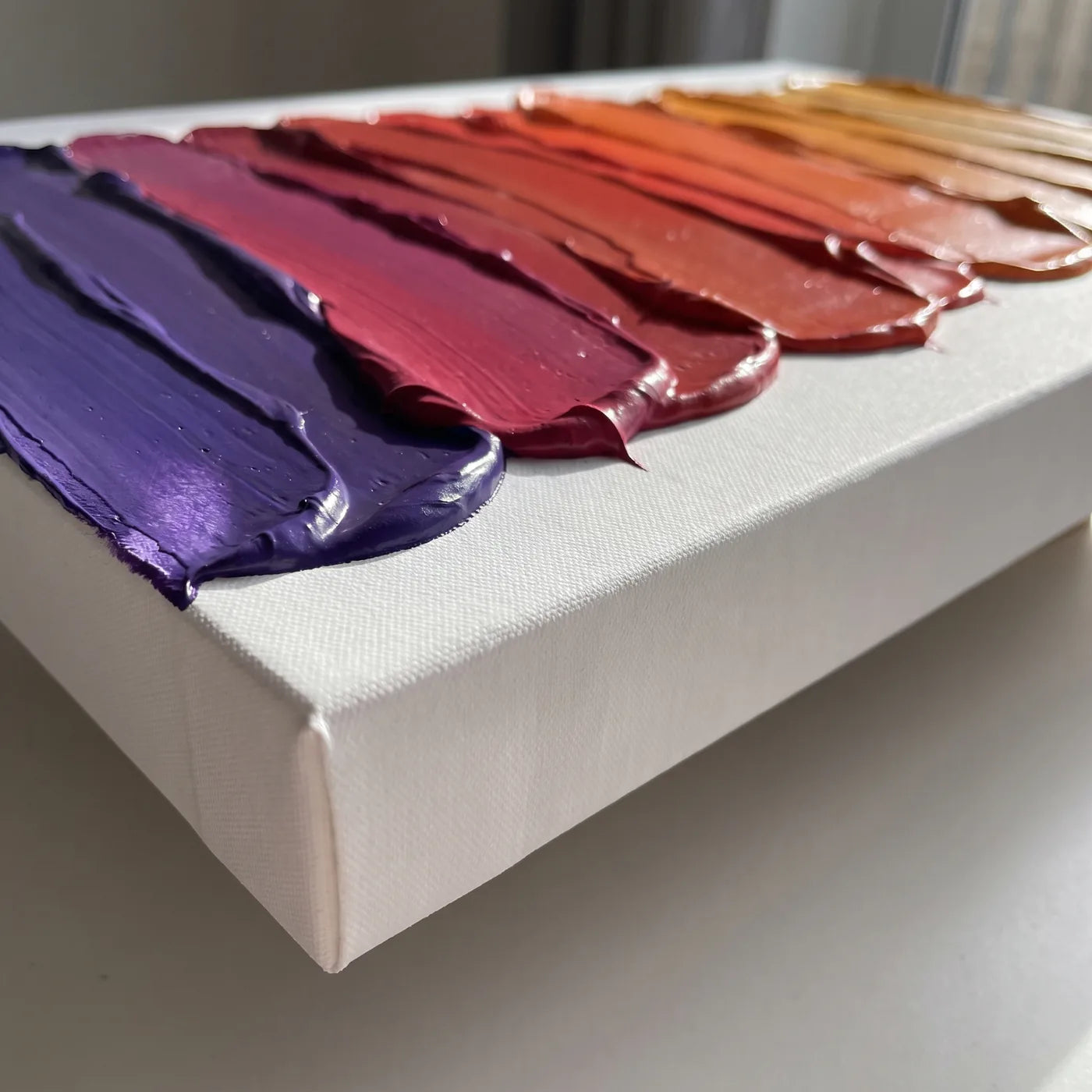 Ακμή του καμβά 3D+ από το πλάι — λευκό πλαϊνό βάθους 5,8 cm και λωρίδες πυκνού ακρυλικού χρώματος με σπάτουλα, καθεμία σε άλλο χρώμα, που μαζί δίνουν μετάβαση από το μοβ στο κεχριμπαρένιο